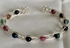 These Celtic inspired knot bracelets, made with tarnish resistant silvertone wire and natural stone beads, are a beautiful look for any wrist. They come in a variety of natural stone materials and your choice of either swirls, pentagram, or triquetra on the ends. *For stone meanings/properties see here Any metals used in jewelry are all nickel free, tarnish resistant (except for copper, which will change color(patina) over time). Metals are either bare copper, silvertone, or goldtone, unless oth Wire Beaded Bracelets, Wire Bracelets Diy, Wire Bracelet Tutorial, Stone Meanings, Knot Bracelets, Diy Wire Jewelry Rings, Wire Bending, Wire Jewelry Rings, Open Bracelet