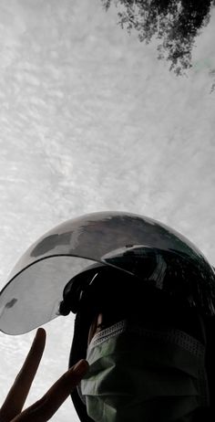 a person wearing a face mask and holding an object in their hand while looking up into the sky