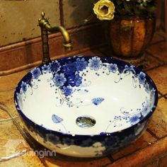 a blue and white bowl sink sitting on top of a counter next to a faucet