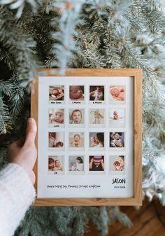 a person holding up a framed photo in front of a christmas tree with pictures on it