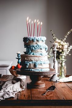 a cake with candles on it sitting on top of a wooden table