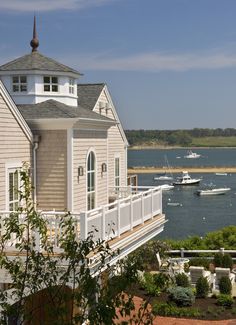 there is a house on the shore with boats in the water