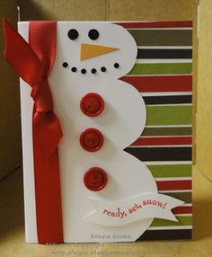 a christmas card with a snowman made out of buttons and ribbon on the front