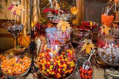 a table filled with lots of candy and candies on top of glass bowls next to each other