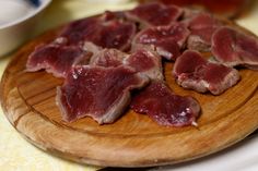 pieces of raw meat on a wooden cutting board