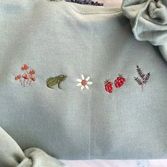 an embroidered sweater with flowers and leaves on it