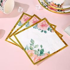 pink roses and gold foiled placemats with matching napkins on a pink surface