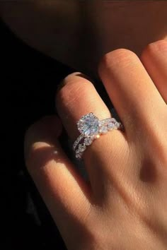 a woman's hand with an engagement ring on it