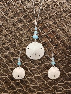 "Gorgeous natural sand dollar necklace with matching earring set. The sand dollars are real and are in their natural condition, and accented with beads in varying shades blue. This would be a gorgeous set for a beach wedding for a bride. bridesmaids, or just a gift for the beach lover in your life. The pendant (approximately 1.5\" across) is set on an 18\", anti-tarnish stainless steel chain that sparkles in the light. Multiple sizes of chain are available. The set is also available in stainless Crafts To Do With Sand Dollars, Nickel Free Ocean-inspired Pendant Jewelry, Nickel-free Ocean-inspired Pendant Jewelry, Nickel-free Ocean-inspired Round Pendant Jewelry, Turquoise Dangle Earrings With Ocean-inspired Style, Turquoise Dangle Earrings Ocean-inspired, Handmade Ocean-inspired Round Pendant Jewelry, Ocean-inspired White Jewelry With Matching Earrings, Ocean-inspired Turquoise Dangle Jewelry