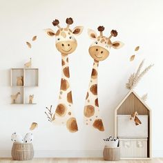 two giraffes standing next to each other in a room with white walls