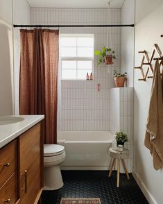 a bathroom with black and white tile flooring next to a bathtub, toilet and sink