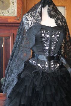 a mannequin wearing a black dress with lace on it