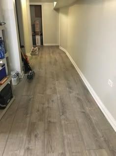 an empty room with hard wood flooring in the middle and white walls on either side