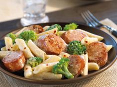 a plate of pasta with broccoli and sausage