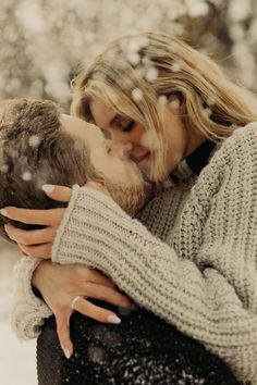 a man and woman kissing in the snow