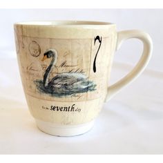 a coffee cup with an image of a swan on the front and writing underneath it