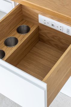 an open drawer with three metal bowls in the bottom and two drawers on each side