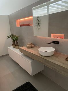 there is a bowl on the counter in this modern bathroom with white walls and flooring