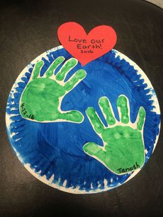 two handprints on a plate with the words love our earth written on it