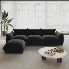 a living room with black couches and a white coffee table in front of a large window