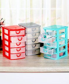 four plastic storage containers sitting on top of a wooden table next to a potted plant