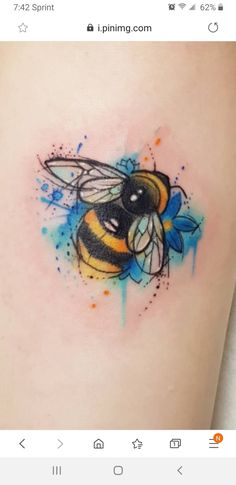 a tattoo on the leg of a woman with a blue and yellow bee in it