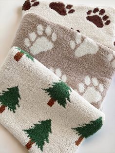 two towels with paw prints and trees on them