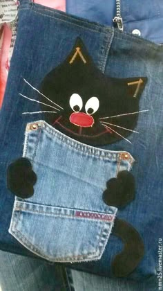 a black cat is sticking its head out of the pocket of a pair of jeans