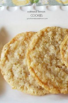 three cookies on a white plate next to a spoon