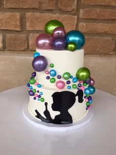 a three tiered cake decorated with colorful balls