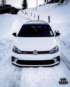 a white car driving down a snow covered road