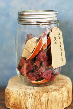 a glass jar filled with dried berries on top of a wooden table next to a tag