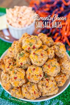 a plate full of sausage balls on top of a green tablecloth with carrots in the background