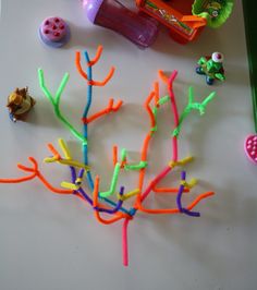 plastic toys are sitting on a table next to a toy tree and other items that include toothbrushes