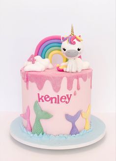 a birthday cake decorated with an unicorn and rainbow