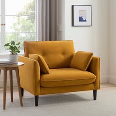 a yellow chair sitting next to a table with a potted plant on top of it