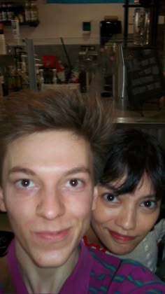 two people posing for the camera in a store with their hair blowing in the wind