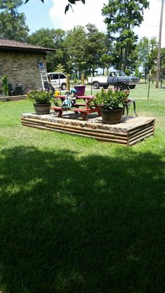 an outdoor garden with potted plants in the grass and a lawn mower sitting on top of it