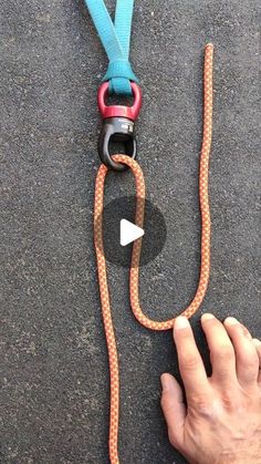 someone is holding onto a rope with a camera attached to it on the ground next to another person's hand