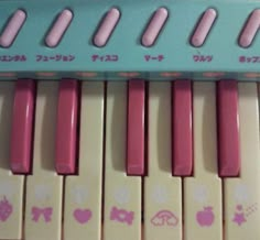 a pink and white toy piano with little stickers on it