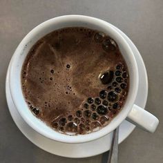 there is a cup of hot chocolate with spoons in it