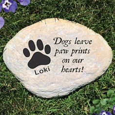 a rock with the words dogs leave paw prints on our hearts