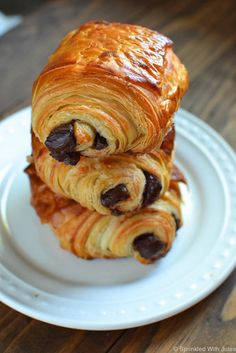 two croissants are stacked on top of each other on a white plate