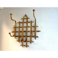 a wall mounted coat rack made out of wood sticks and hooks on a white wall