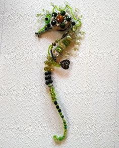 a seahorse made out of glass beads and other bead work on a white surface