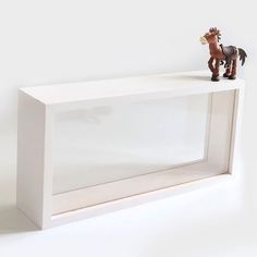 a toy horse on top of a white shelf