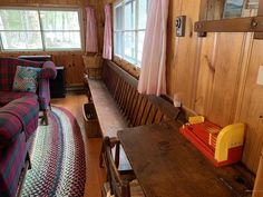 a living room filled with furniture and wooden walls