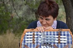 a woman holding a picnic basket with utensils in it