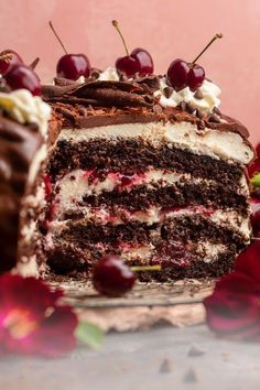 a chocolate cake with cherries and whipped cream