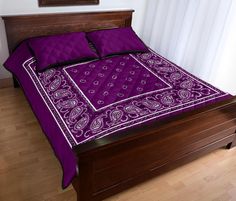 a bed with a purple blanket and matching pillows